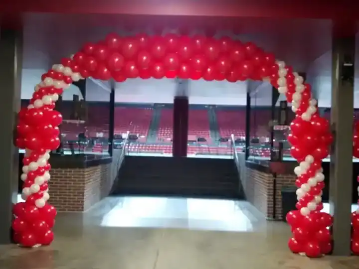Red and white spiral balloon arch at an arena entrance before the doors open