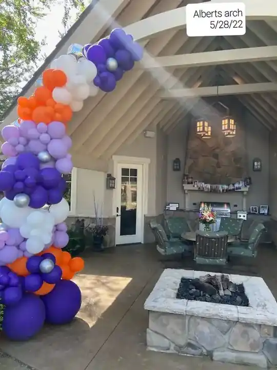 Purple, orange and white balloon garland on a covered patio