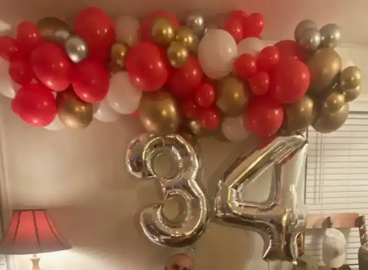 Red and gold balloons over a silver 34 number
