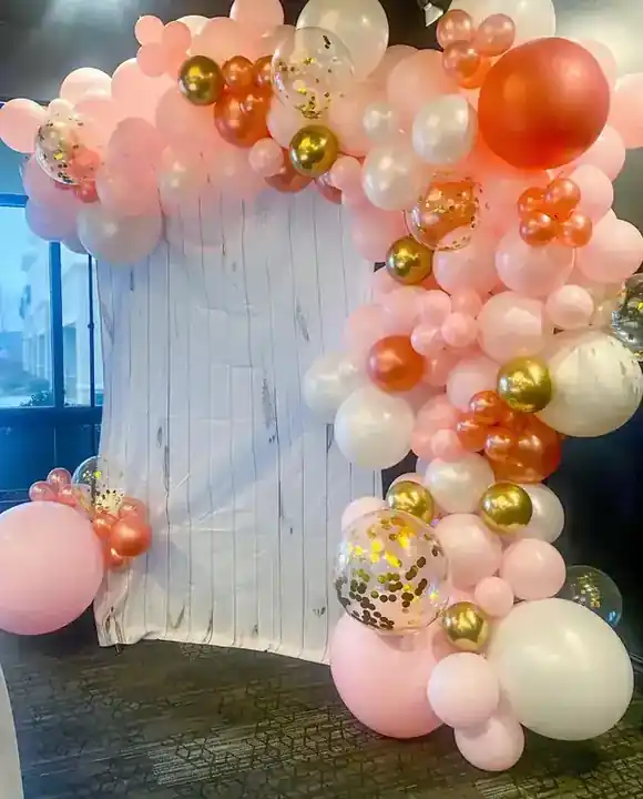 Peach, white and copper balloon garland over a draped backdrop