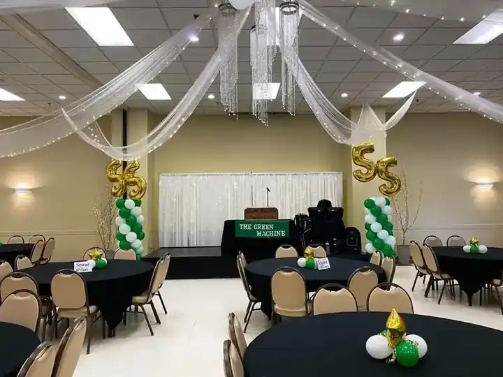 Banquet hall dressed with gold 55 number columns and balloon centrepieces