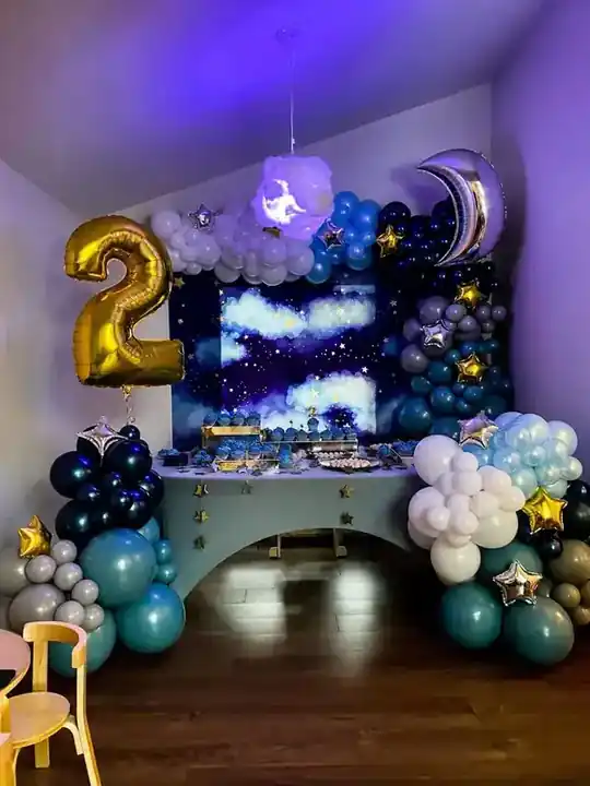 Navy and white balloon garland with a gold 2 around a starry backdrop
